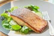 Stekt laksefilet med sprøtt skinn på en frisk grønn salat