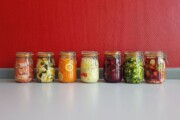 Sju glass med fargerike grønnsaker og kål til fermentering